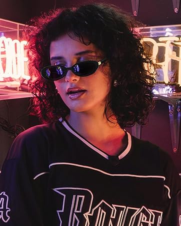 Maglia o top nero in stile sportivo con scritte scritte, fotografato di notte con luci al neon che creano un bagliore ambientale viola.