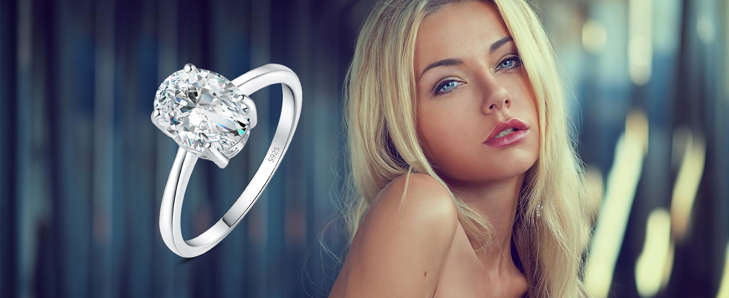 Delicato anello di fidanzamento in argento con un prominente solitario di diamante rotondo incastonato a griffe, visualizzato su uno sfondo sfocato