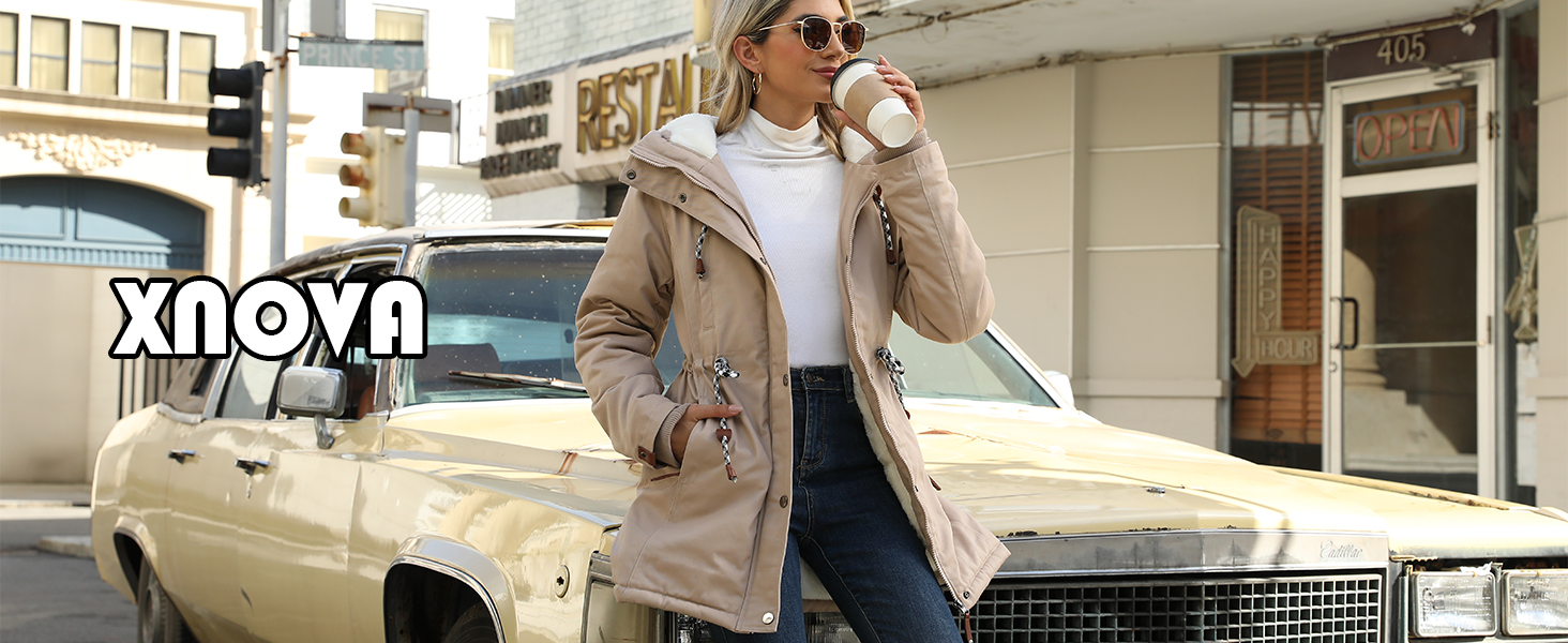 Piumino invernale beige con cappuccio mostrato sullo sfondo di auto d'epoca